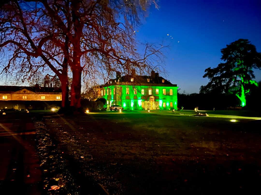 Babington House wedding venue with beautiful exterior LED mood lighting in green tones, showcasing luxury wedding lighting design