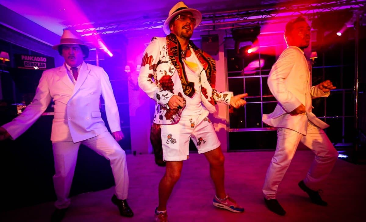 Live hybrid entertainment — high-energy performers with professional production lighting