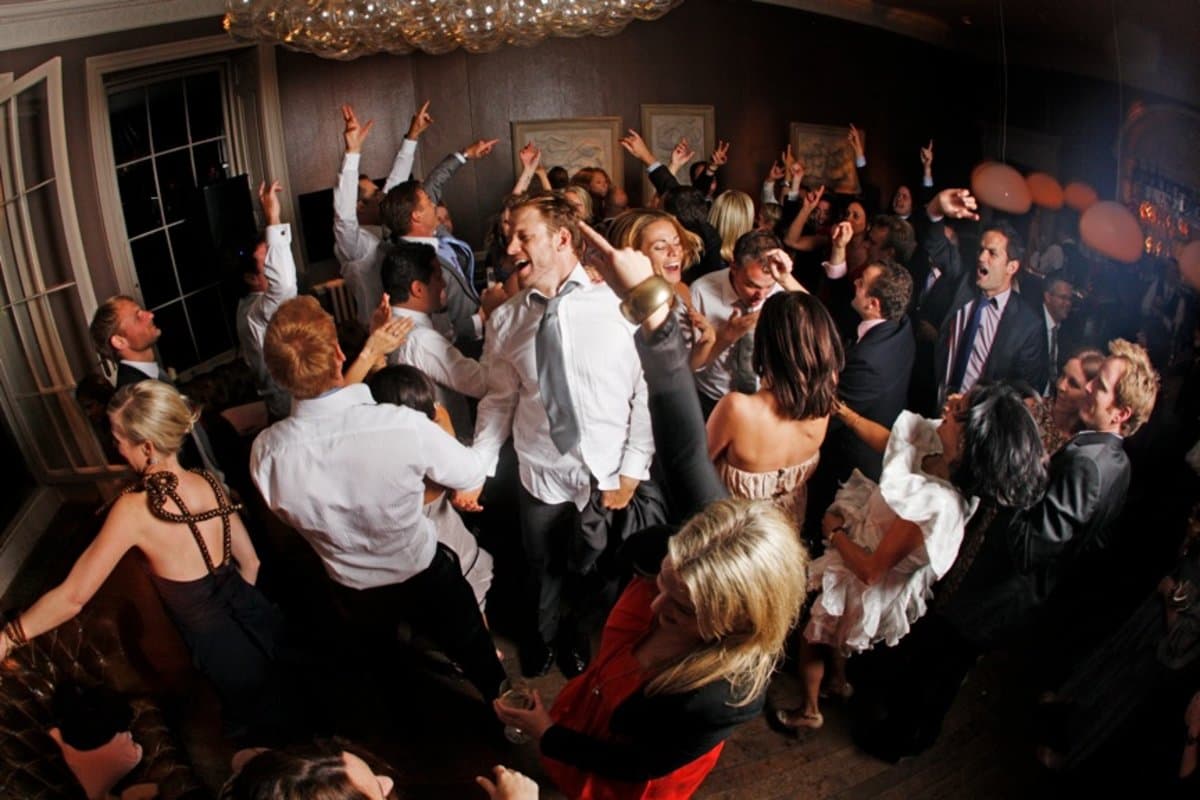 Packed wedding dancefloor with guests dancing — professional wedding DJ entertainment