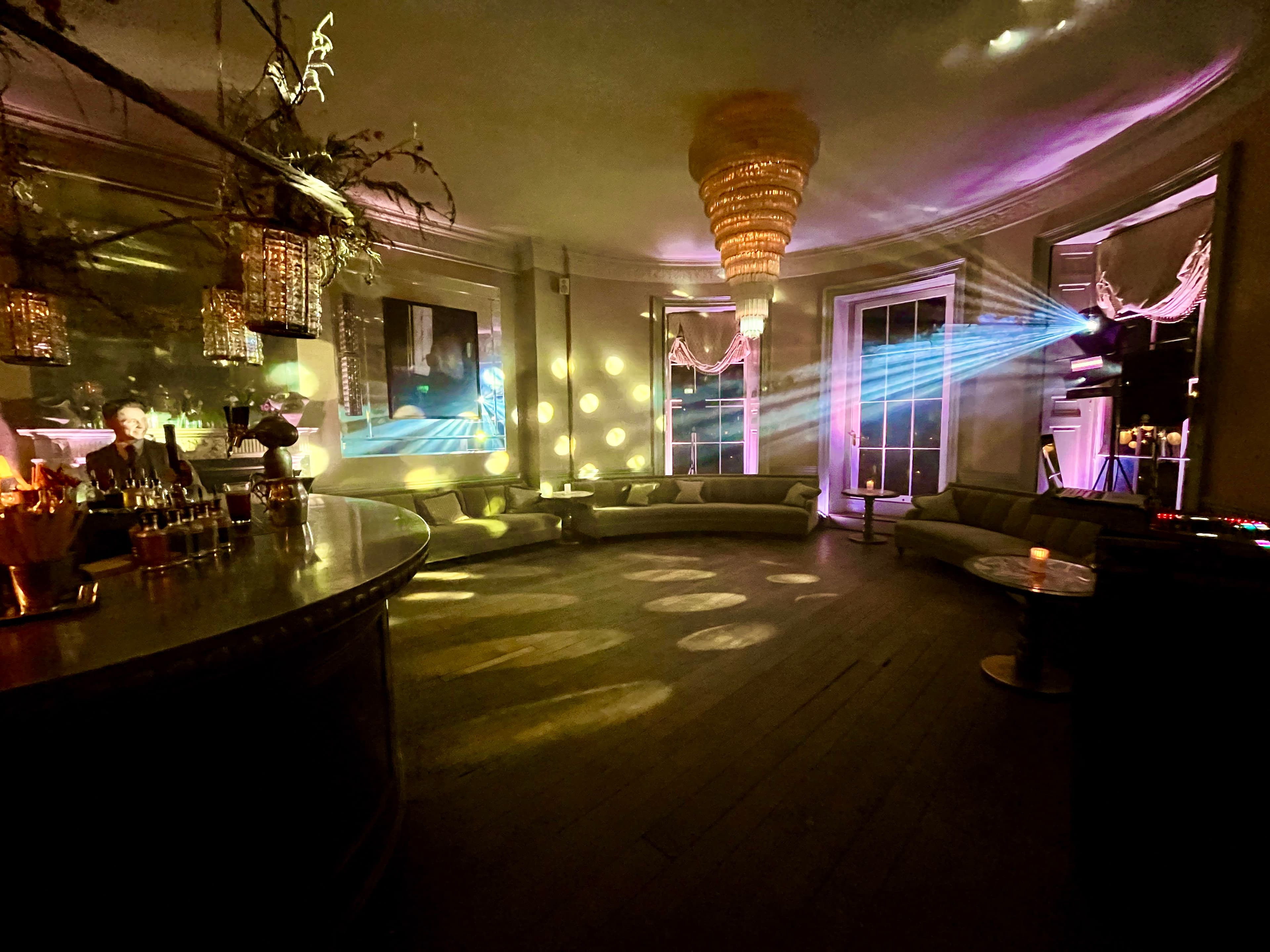 Babington House bar with DJ Nige's setup and atmospheric party lighting for a late night celebration