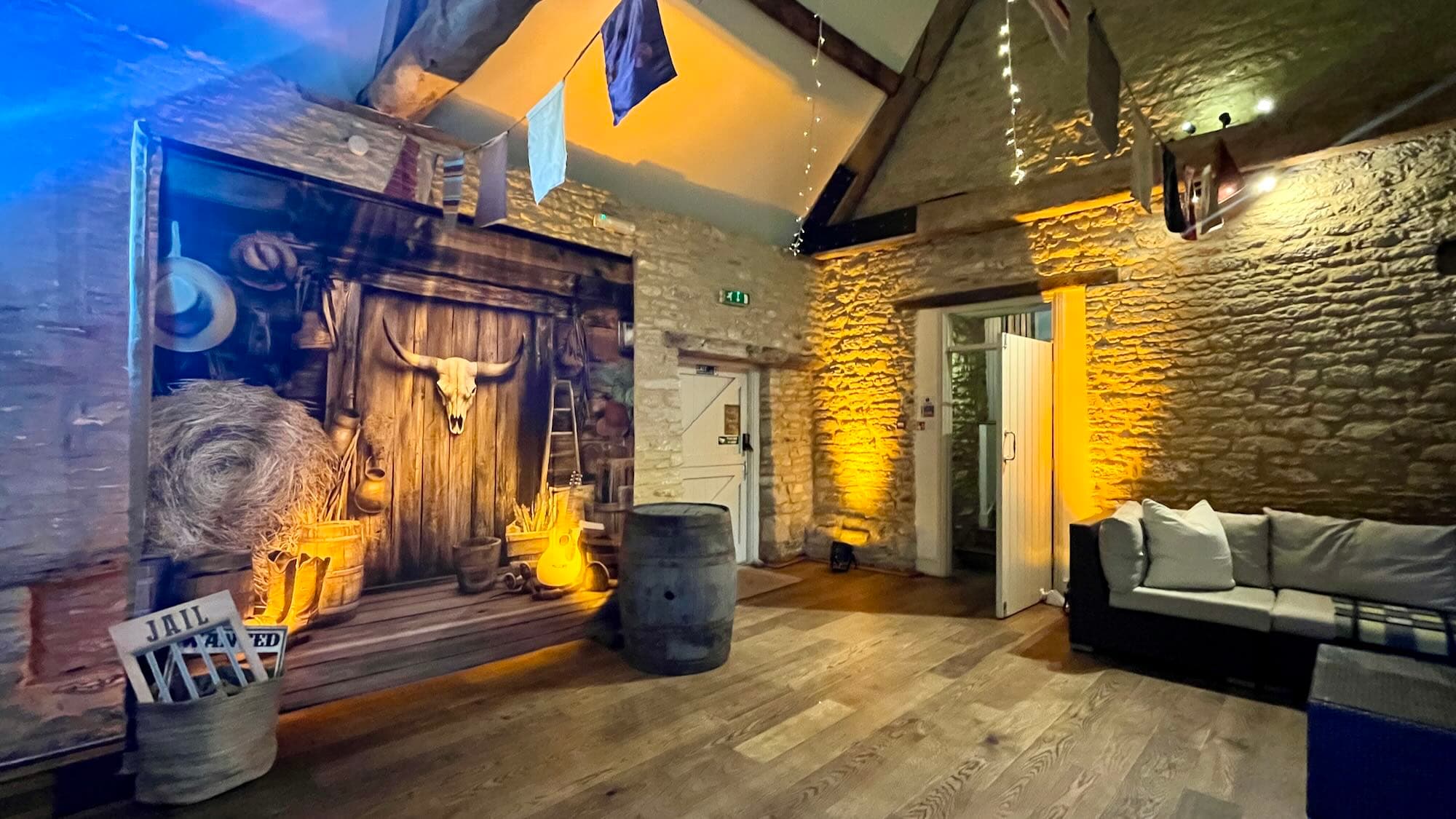 Wild West themed banquet hall with long tables, bunting and Edison festoon lighting